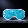Nimbus Cold Gel Eye Mask, teal gel-bead cooling mask, on a frosted slate shelf