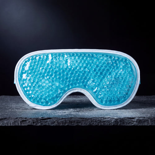 Nimbus Cold Gel Eye Mask, teal gel-bead cooling mask, on a frosted slate shelf
