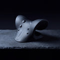 Nimbus Neck Stretcher, black cervical support pillow, on a frosted slate shelf